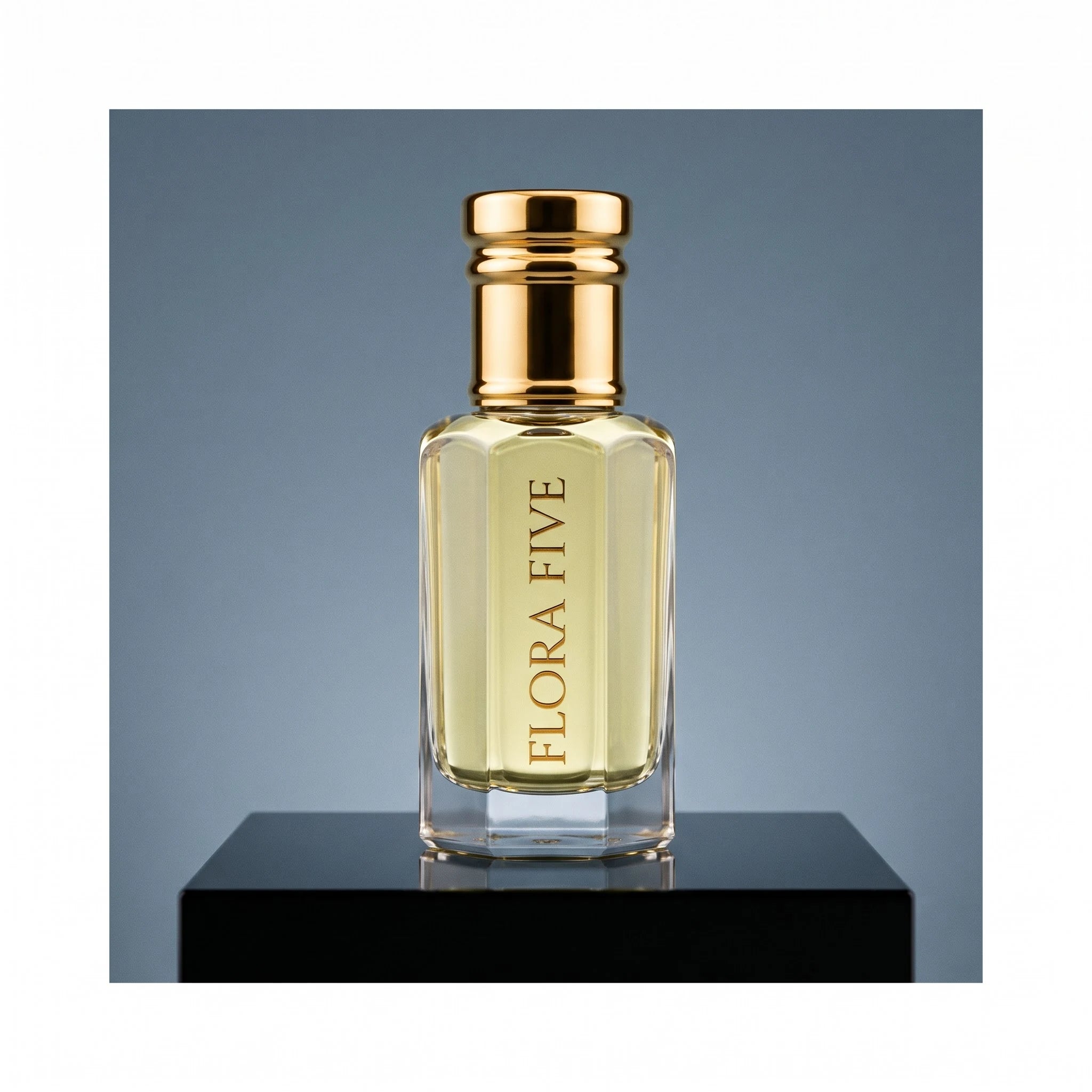 YSL Y inspired attar for men — alcohol-free perfume oil by Flora Five: pale gold oil on a black plinth against a steel-blue backdrop