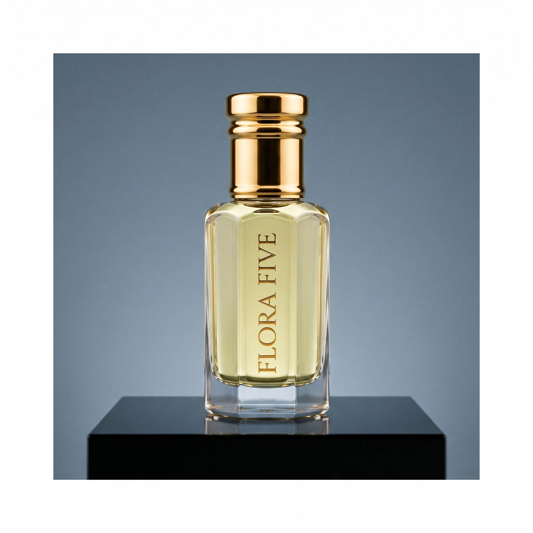 YSL Y inspired attar for men — alcohol-free perfume oil by Flora Five: pale gold oil on a black plinth against a steel-blue backdrop